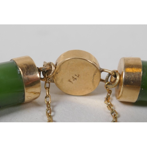 626 - A yellow metal mounted spinach jade bracelet decorated with Chinese characters, marked 14, 18cm long