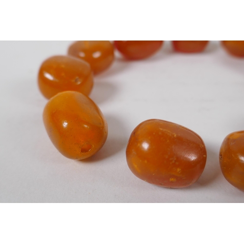 629 - A quantity of loose butterscotch amber beads, 51g