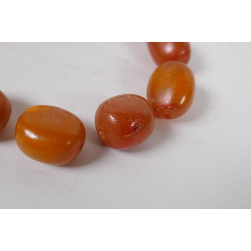 629 - A quantity of loose butterscotch amber beads, 51g