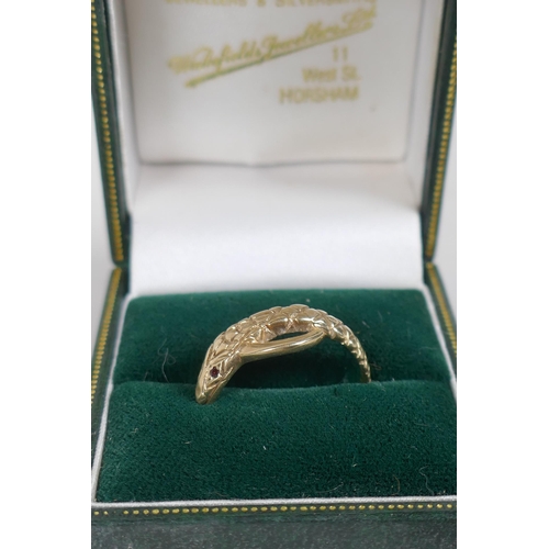 676 - A 9ct gold snake ring set with ruby eyes, 3g