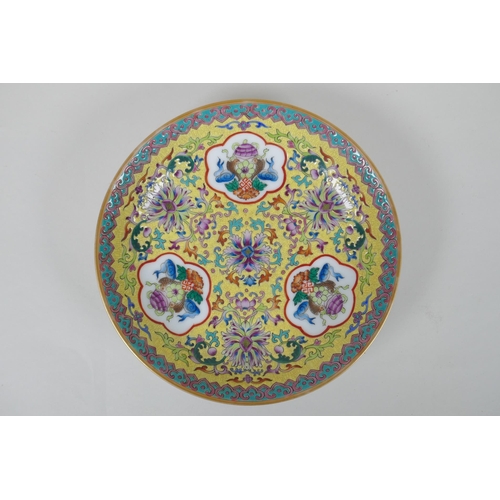 70 - A Chinese polychrome porcelain dish decorated with auspicious symbols and lotus flowers on a yellow ... 