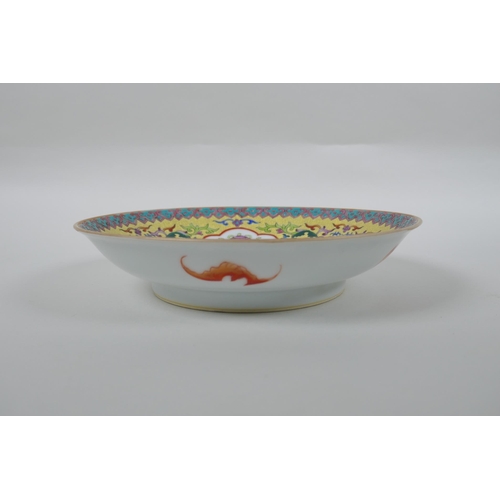 70 - A Chinese polychrome porcelain dish decorated with auspicious symbols and lotus flowers on a yellow ... 