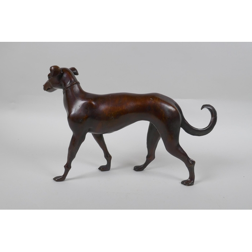 74 - A filled bronze figure of a dog, 32cm long