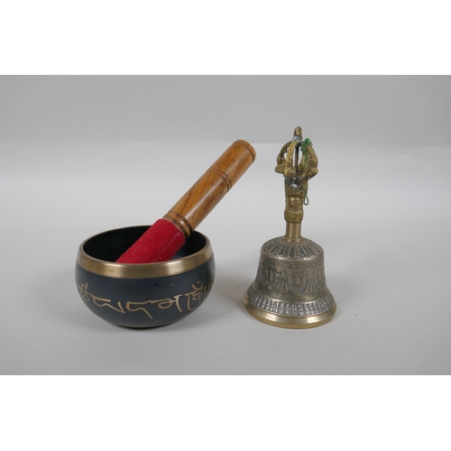 293 - A Tibetan bronze singing bowl and beater with script decoration, a brass ceremonial bell with silver... 