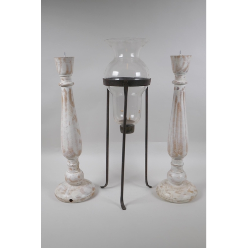 301 - A pair of turned and distressed pricket candlesticks, and a wrought iron and glass hurricane vase, l... 