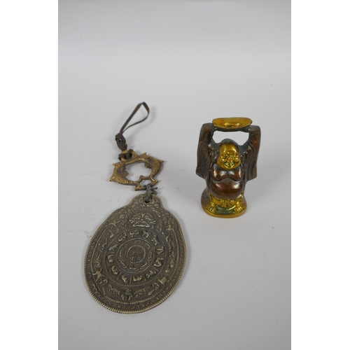 305 - A Tibetan bronze and silvered metal calendar pendant, together with a bronze figure of a jolly Buddh... 