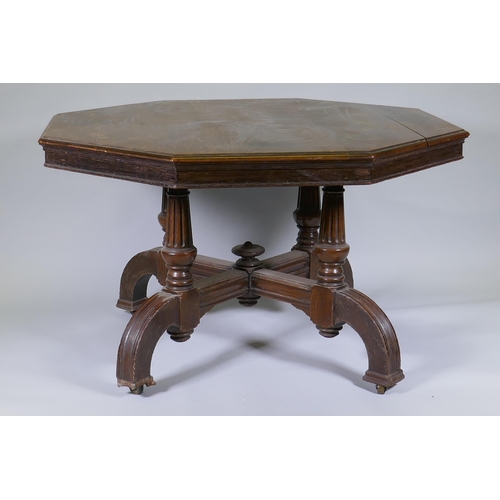 1002 - A Victorian oak centre table with octagonal top, raised on four fluted columns and shaped supports w... 