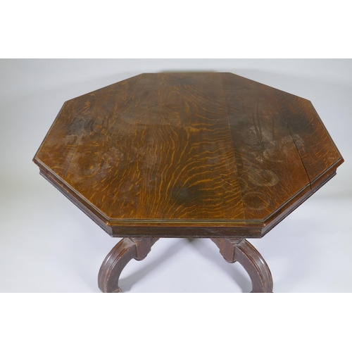 1002 - A Victorian oak centre table with octagonal top, raised on four fluted columns and shaped supports w... 