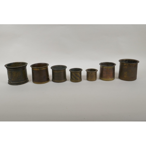 101 - A collection of seven antique Persian bronze measures, of graduated sizes, largest 9cm high x 10cm d... 