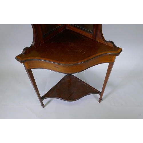 1011 - A Victorian mahogany corner display cabinet with single bow front glazed cupboard, mirror back and s... 