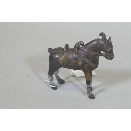 103 - An Eastern bronze figure of a horse with saddle, 10cm high