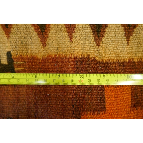 1039 - A large Middle Eastern orange and burgundy ground hand woven kilim carpet, 310 x 500cm