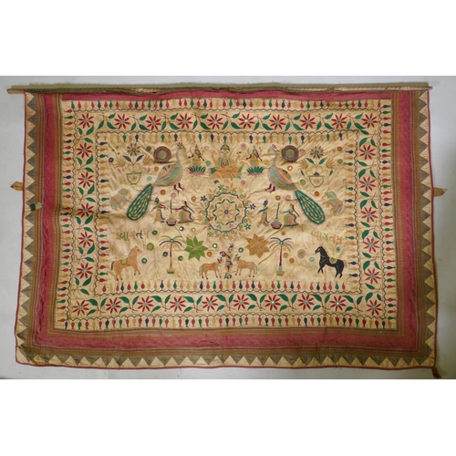 105 - A C19th Indian embroidered wall hanging decorated with depictions of Ganesh, peacocks, elephants, co... 