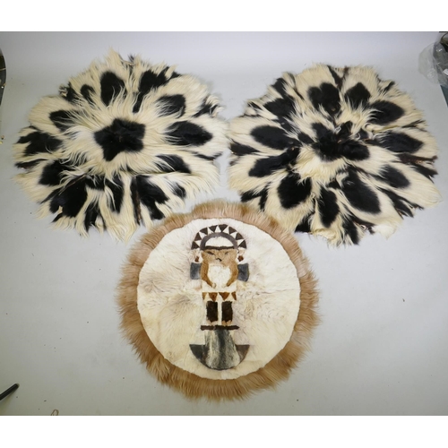 1050 - A pair of circular animal fur rugs, and another with lion design, largest 120cm diameter