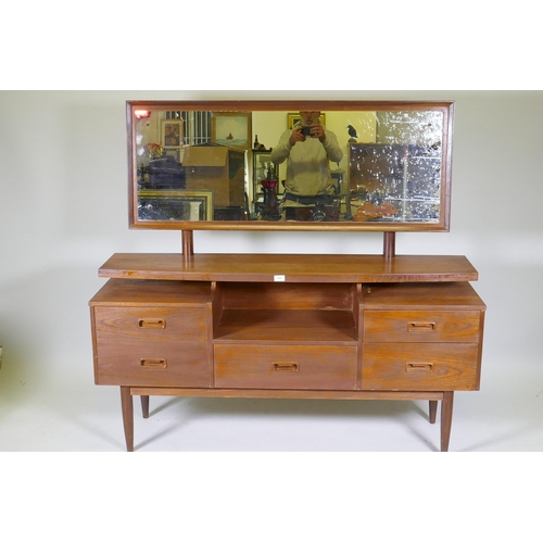 1051 - A mid century teak veneer dressing table with floating top, adjustable mirror and five drawers, 144 ... 