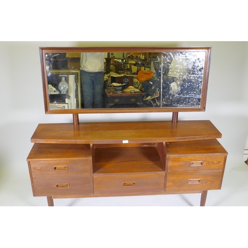 1051 - A mid century teak veneer dressing table with floating top, adjustable mirror and five drawers, 144 ... 