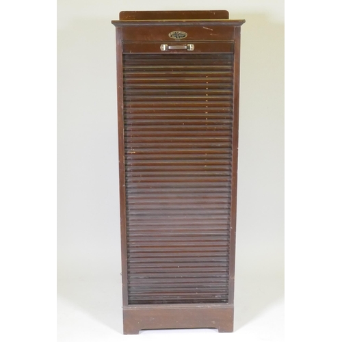 1053 - An early C20th oak tambour fronted music/filing cabinet, by Wolfe & Hollander Ltd of London, 48 ... 