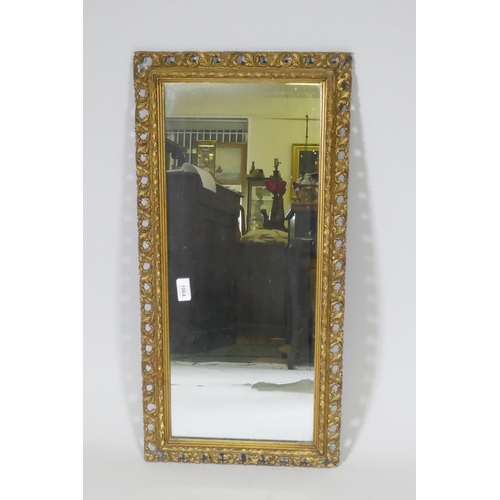 1064 - A gilt wood and composition framed wall mirror with pierced border, early C20th, 37 x 76cm