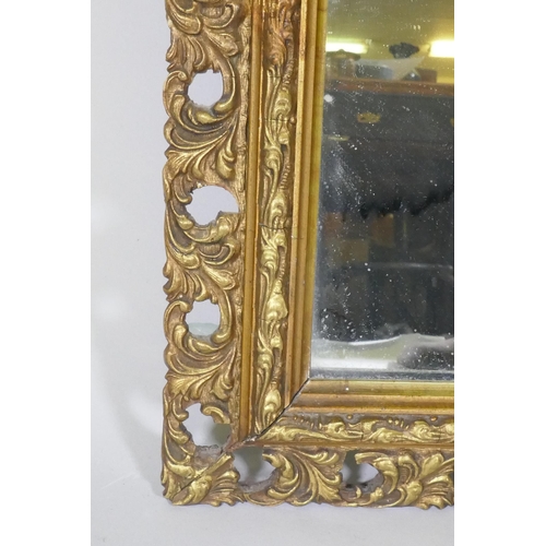 1064 - A gilt wood and composition framed wall mirror with pierced border, early C20th, 37 x 76cm