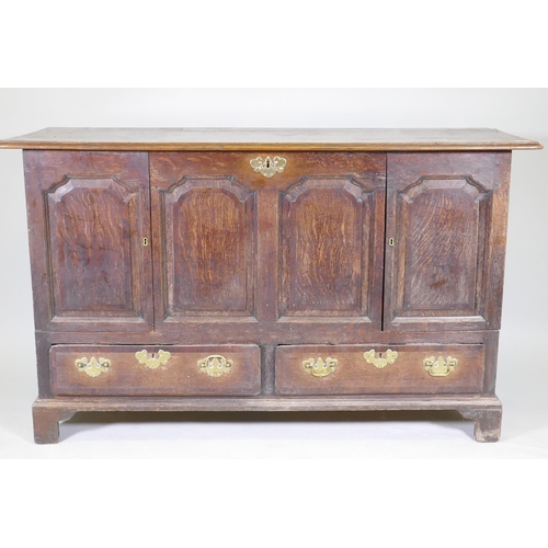 1069 - A C19th North Country oak four panel mule chest, adapted with two cupboards over two drawers, and or... 