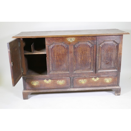 1069 - A C19th North Country oak four panel mule chest, adapted with two cupboards over two drawers, and or... 