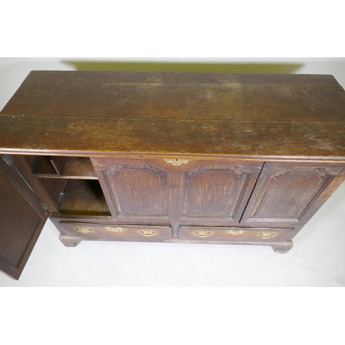 1069 - A C19th North Country oak four panel mule chest, adapted with two cupboards over two drawers, and or... 