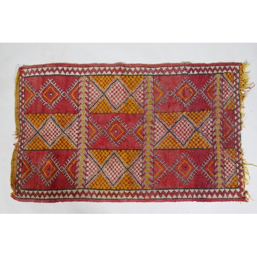 1073 - A Turkish red and yellow ground rug with geometric design, 125 x 74cm