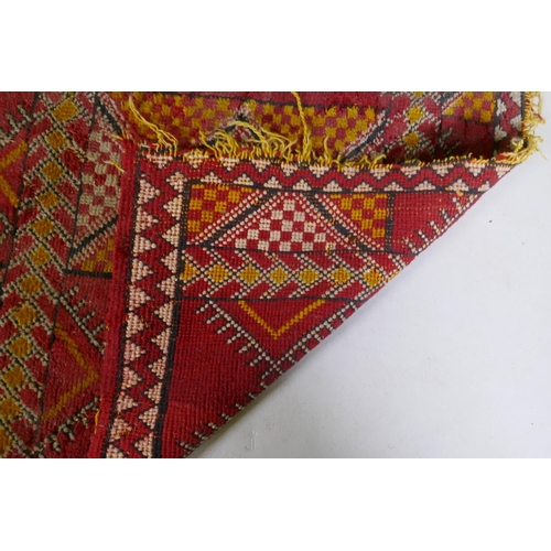 1073 - A Turkish red and yellow ground rug with geometric design, 125 x 74cm