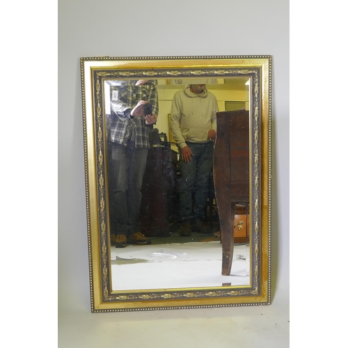 1077 - A contemporary gilt wall mirror with moulded decoration, 103 x 76cm