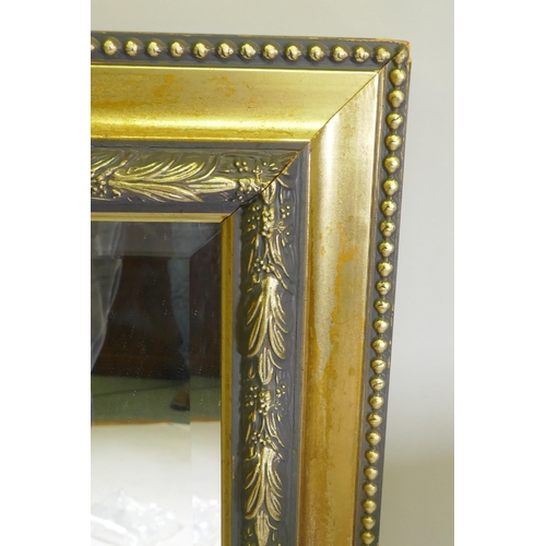 1077 - A contemporary gilt wall mirror with moulded decoration, 103 x 76cm