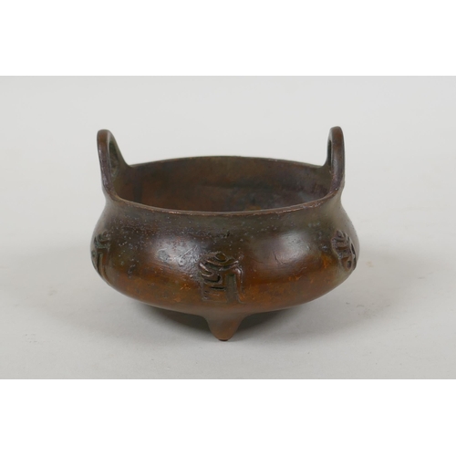 108 - A Chinese bronze two handled censer on tripod supports with character decoration, Xuande 6 character... 