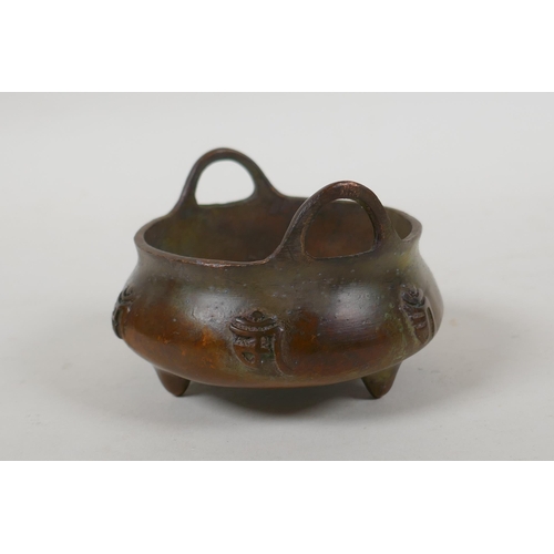 108 - A Chinese bronze two handled censer on tripod supports with character decoration, Xuande 6 character... 