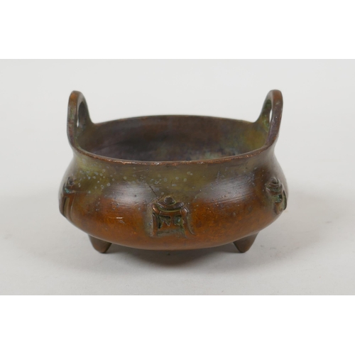 108 - A Chinese bronze two handled censer on tripod supports with character decoration, Xuande 6 character... 