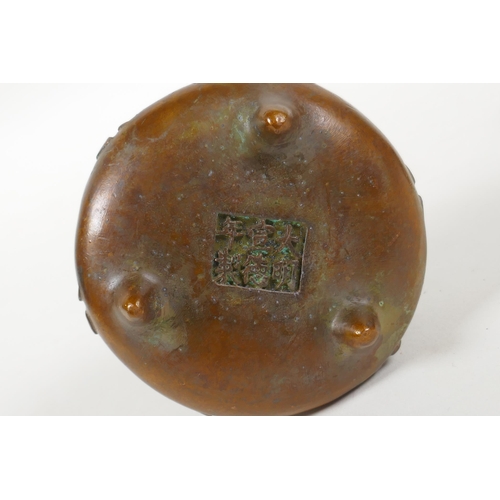 108 - A Chinese bronze two handled censer on tripod supports with character decoration, Xuande 6 character... 