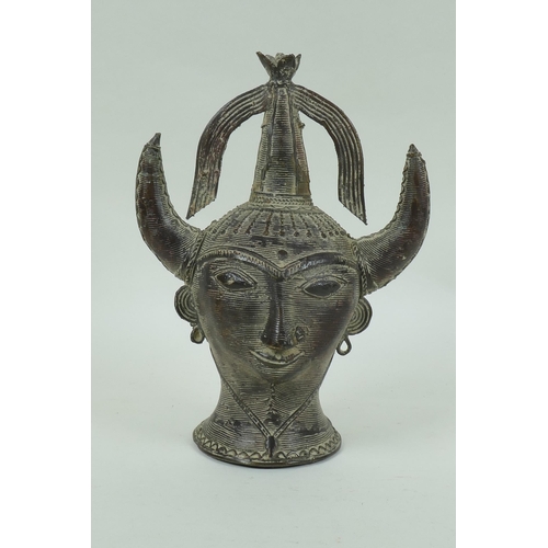 111 - An Eastern bronze head of Saturn with horned headdress, 20cm high