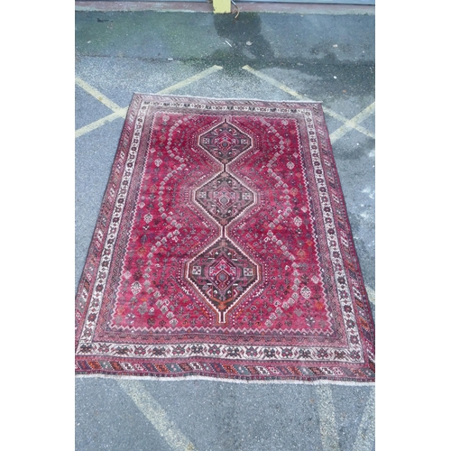 1128 - A Persian washed red ground full pile Qashqai tribal carpet, 216 x 294cm