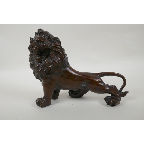 142 - A filled bronze statue of a lion, 28cm long