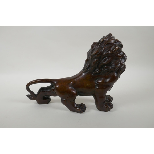 142 - A filled bronze statue of a lion, 28cm long