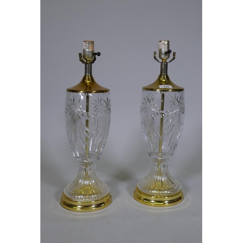 143 - A pair of cut glass table lamps with polished brass mounts and bases, 51cm high