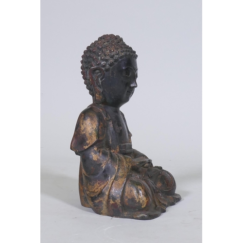 152 - An oriental painted and gilt brass figure of Buddha, 22cm high