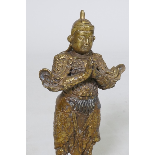 160 - A Chinese bronze figure of a warrior god, hands clasped in prayer, impressed seal mark verso, 23cm h... 