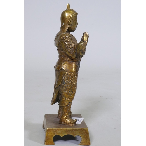 160 - A Chinese bronze figure of a warrior god, hands clasped in prayer, impressed seal mark verso, 23cm h... 