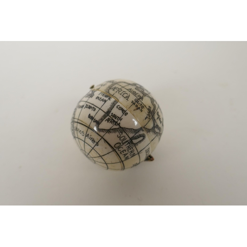 177 - A nautical style carved bone compass and sundial in the form of a globe, 4cm diameter