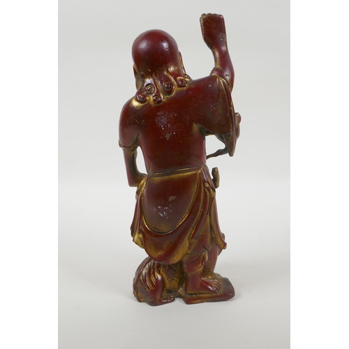 188 - A Chinese gilt and copper lacquered bronze figure of Lohan