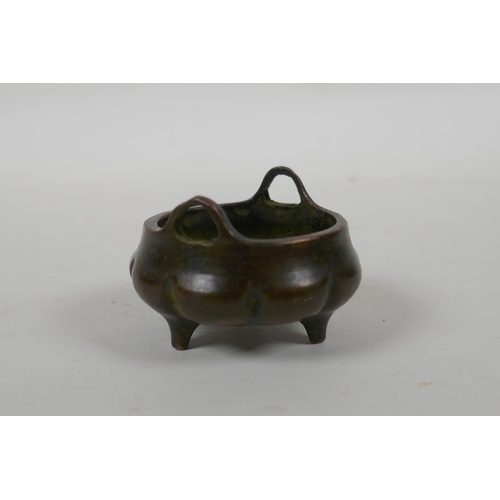 196 - An antique Chinese miniature bronze censer of gourd form with two handles and tripod supports, impre... 