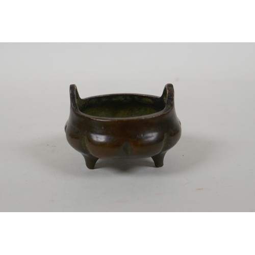 196 - An antique Chinese miniature bronze censer of gourd form with two handles and tripod supports, impre... 