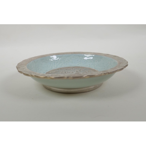 198 - A Chinese celadon and silver glazed porcelain bowl with lobed rim, decorated with a dragon and lotus... 