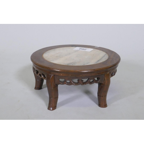 202 - A Chinese hardwood stand with pierced frieze and inset marble top, 18cm diameter and 8cm high