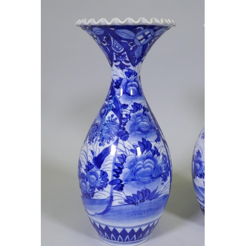 204 - A pair of Arita blue and white vases with flared necks and frilled rims, AF repairs to necks, 45cm h... 