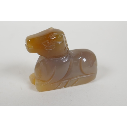 208 - A Chinese apple green jade carved Buddha pendant, an agate carving of a horse and a carved hardstone... 